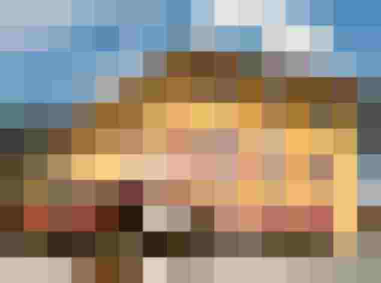 Yellow Alpine Hotel with Red Lettering, Terrace, Sun Umbrellas and Mountain Scenery