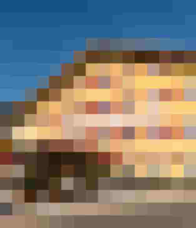 Gelbes Traditionshotel mit rotem Schriftzug und Sonnenterrasse im Salzburger Land