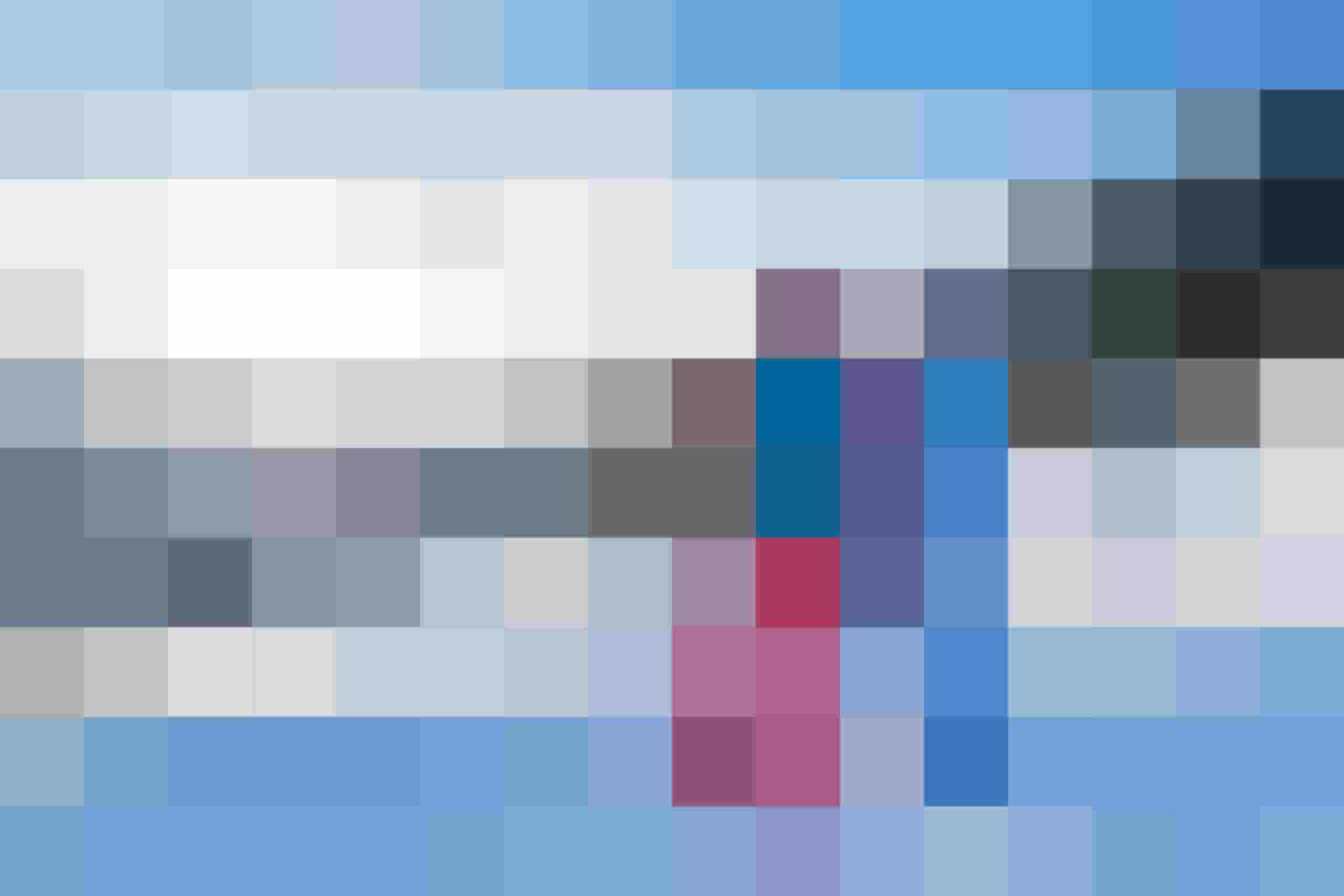 Two people in winter clothing hike through a snowy alpine landscape in sunshine