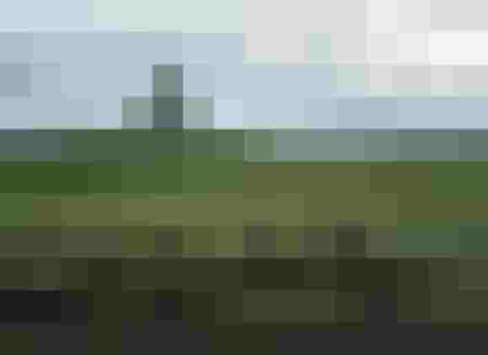 Three Cyclists on a Gravel Path in Front of Green Meadows and an Alpine Panorama