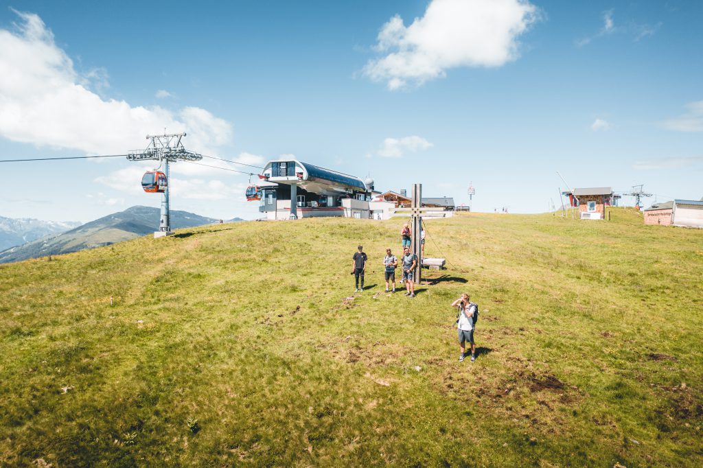 Summer alpine meadow with hikers, Panorama Lift, and mountain station in the Hohe Tauern National Park